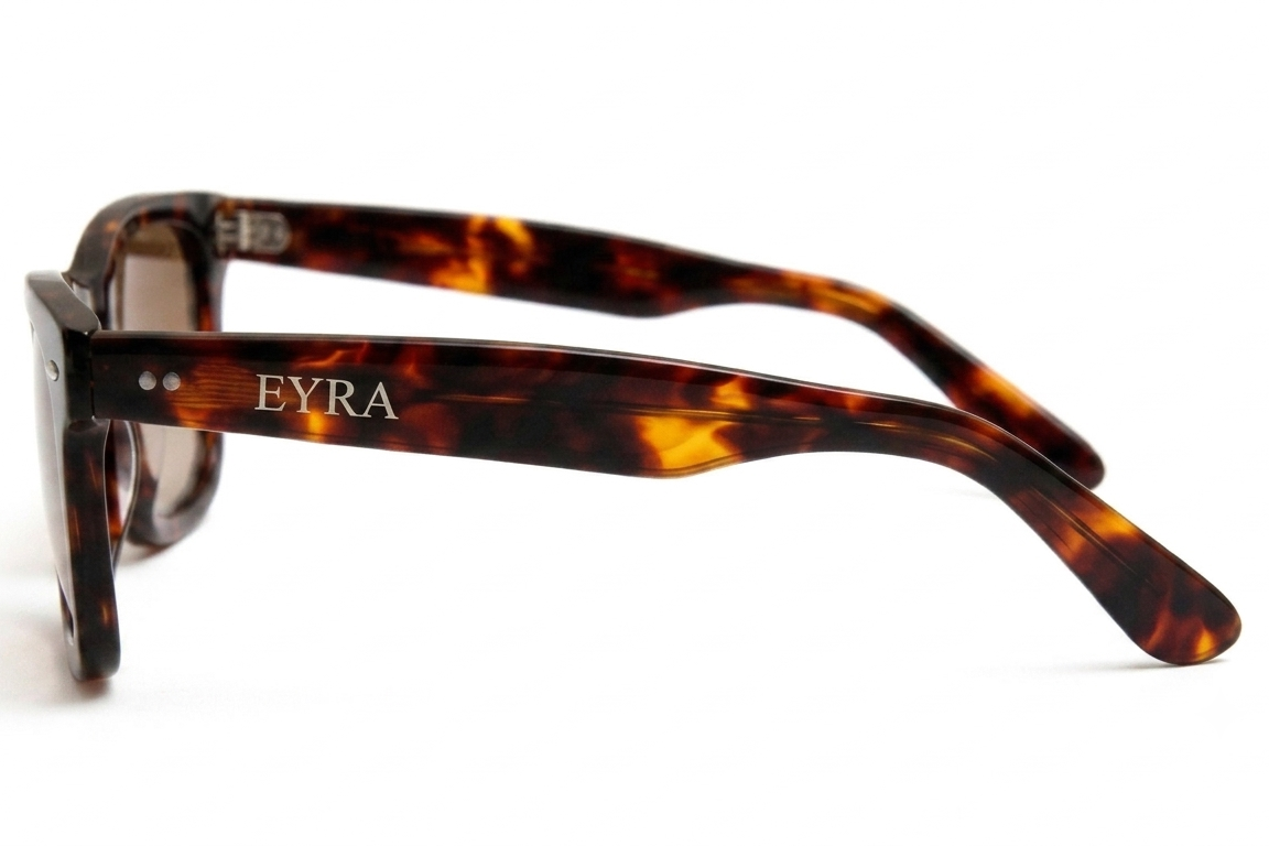 Tortoiseshell sunglasses with 'EYRA' branding on a white background